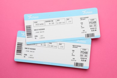 Photo of Travel agency. Flight tickets on pink background, top view