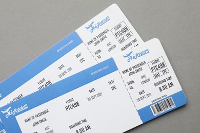 Photo of Travel agency. Flight tickets on grey background, top view