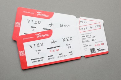 Photo of Travel agency. Flight tickets on grey background, top view