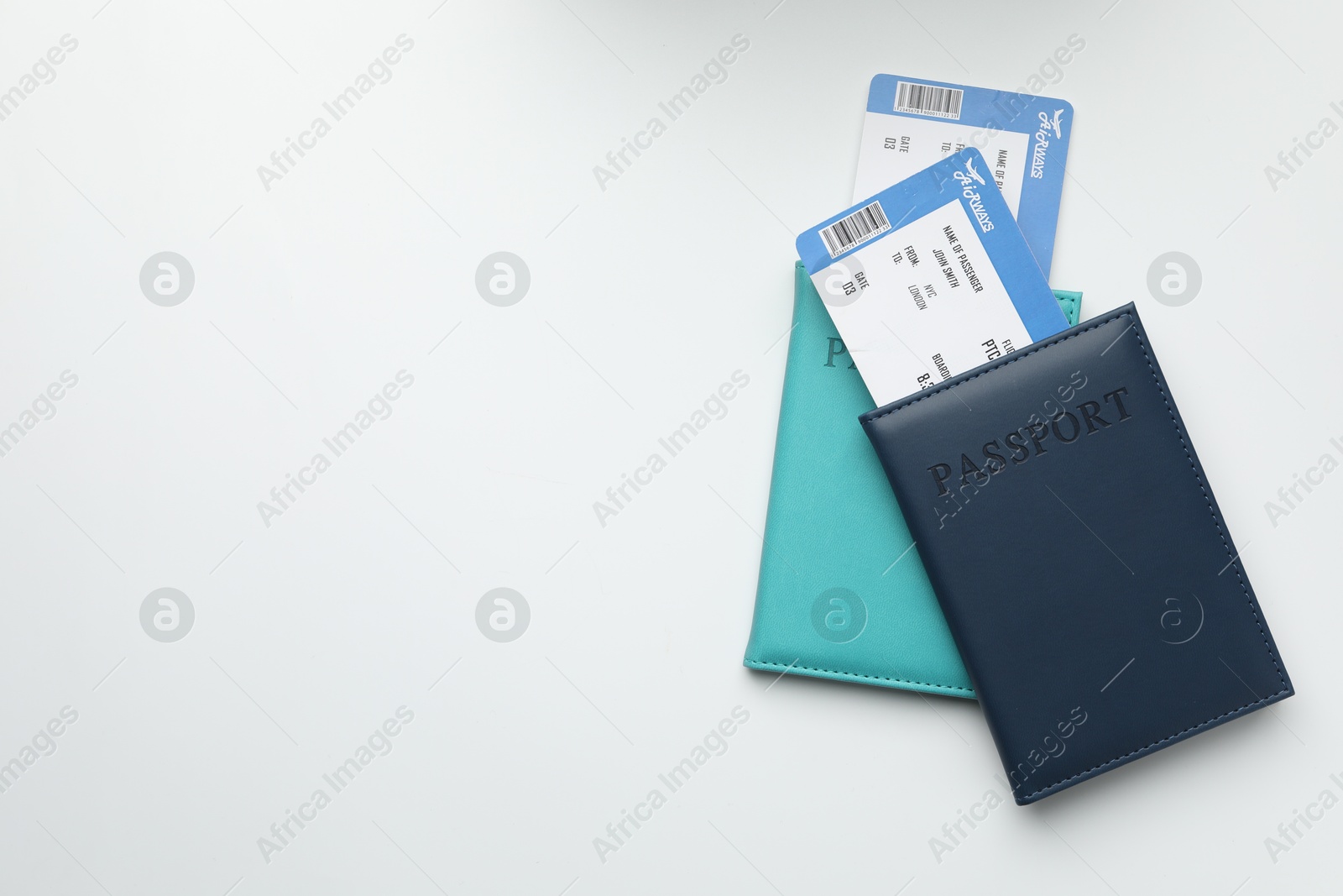 Photo of Travel agency. Flight tickets and passports on light background, top view. Space for text