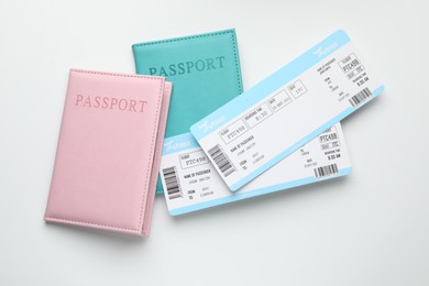 Photo of Travel agency. Flight tickets and passports on light background, flat lay