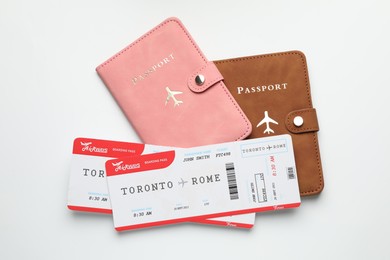 Photo of Travel agency. Flight tickets and passports on light background, flat lay