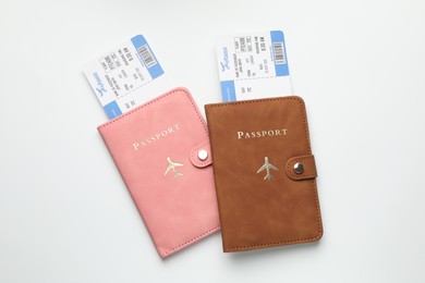 Photo of Travel agency. Flight tickets and passports on light background, top view