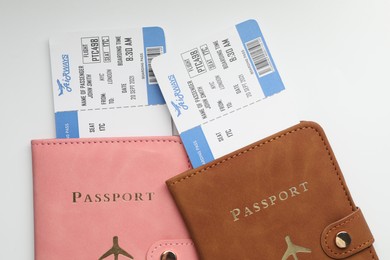 Photo of Travel agency. Flight tickets and passports on light background, top view