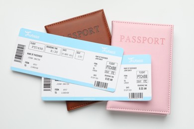 Photo of Travel agency. Flight tickets and passports on light background, top view