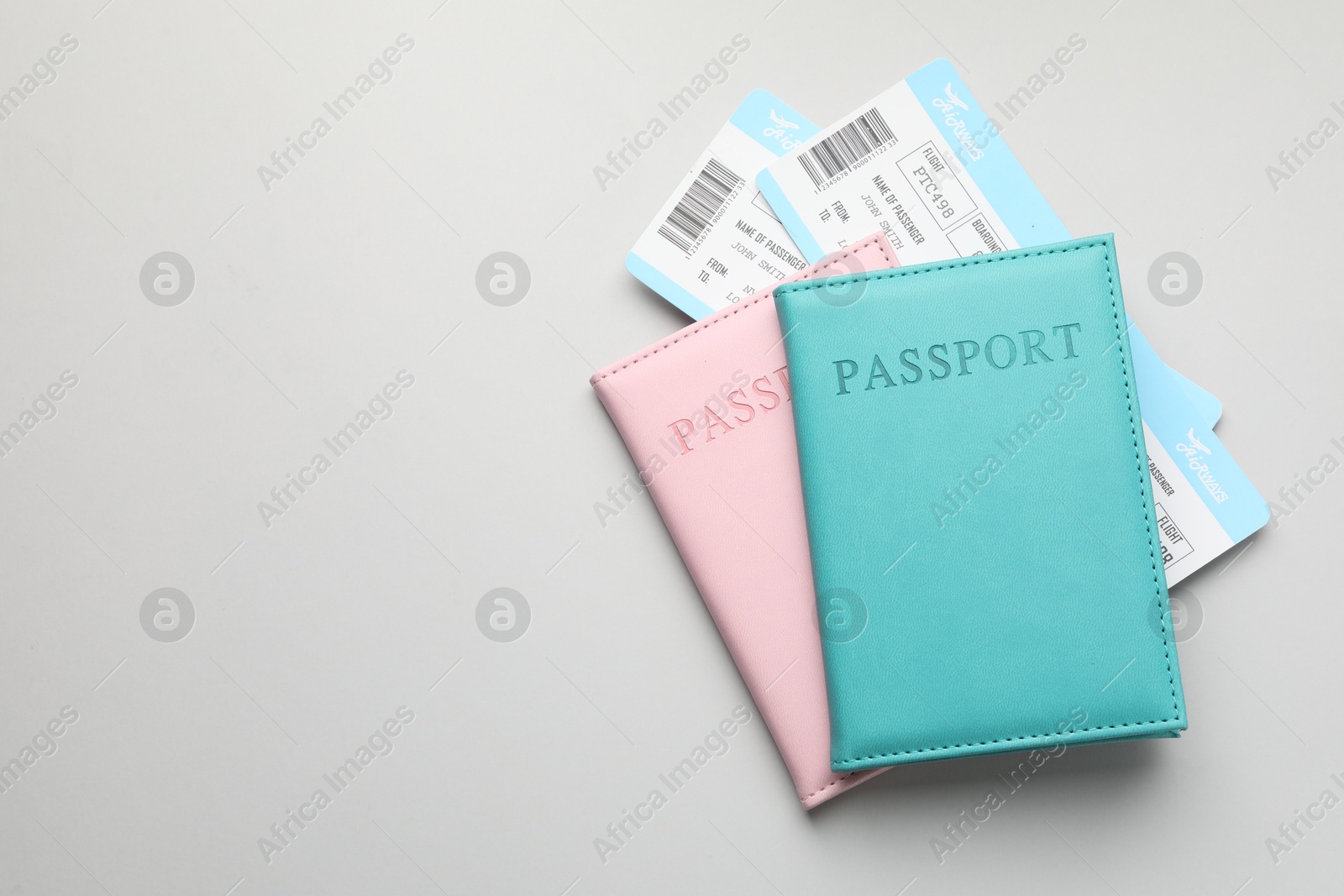 Photo of Travel agency. Flight tickets and passports on grey background, top view. Space for text