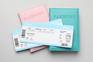 Photo of Travel agency. Flight tickets and passports on grey background, top view