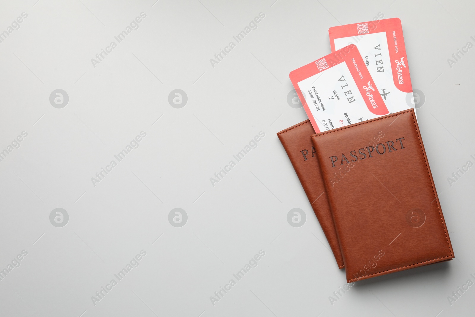 Photo of Travel agency. Flight tickets and passports on grey background, top view. Space for text