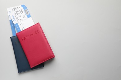 Photo of Travel agency. Flight tickets and passports on grey background, top view. Space for text