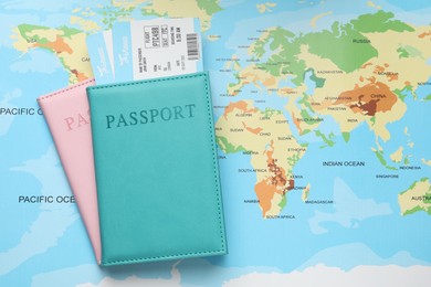 Photo of Travel agency. Flight tickets and passports on world map, flat lay