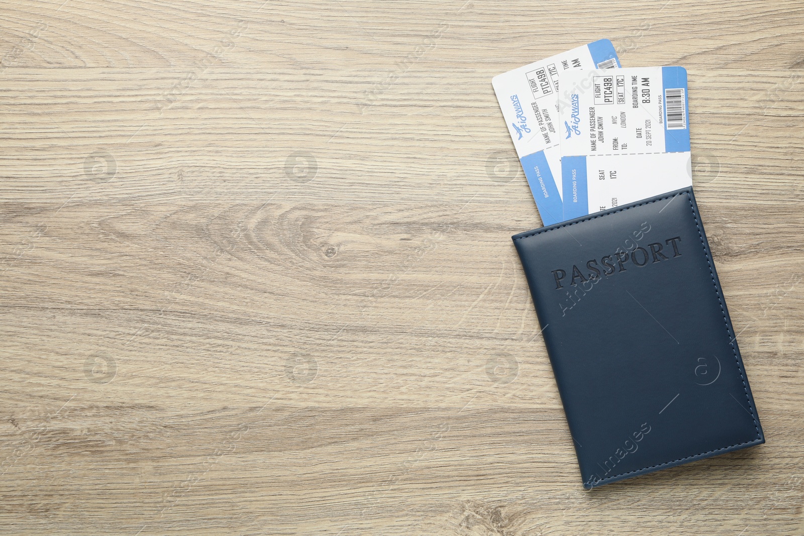 Photo of Travel agency. Flight tickets and passport on wooden table, top view. Space for text