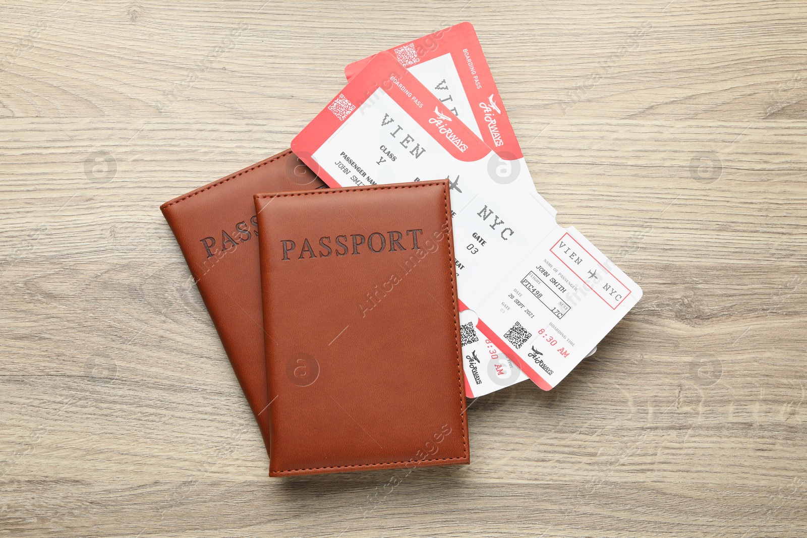 Photo of Travel agency. Flight tickets and passports on wooden table, flat lay