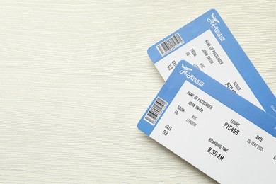 Photo of Travel agency. Flight tickets on light wooden table, top view. Space for text