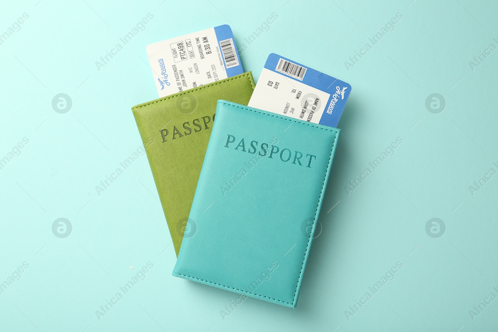 Photo of Passports with tickets on light blue background, top view