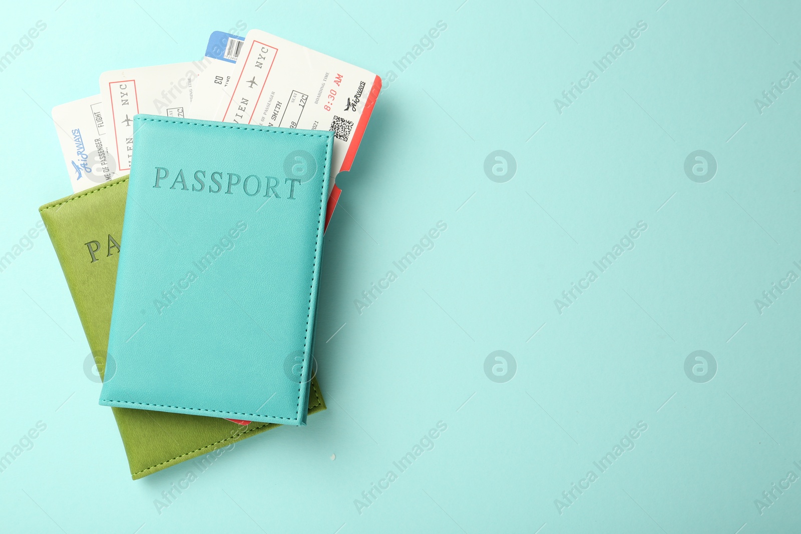 Photo of Passports with tickets on light blue background, top view. Space for text