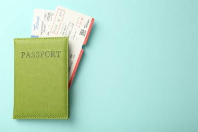 Photo of Passport with tickets on light blue background, top view. Space for text