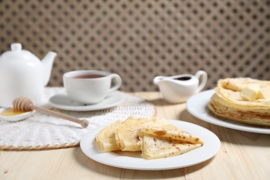 Photo of Tasty crepes served on wooden table, closeup