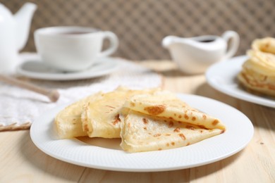 Photo of Tasty crepes on wooden table, closeup view