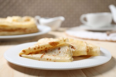 Photo of Tasty crepes on wooden table, closeup view