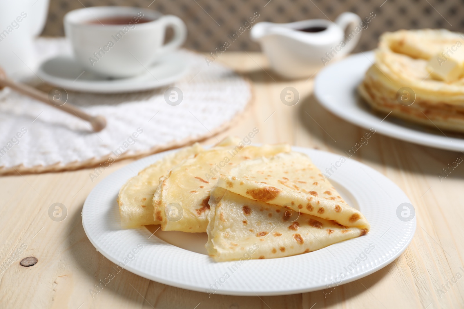 Photo of Tasty crepes served on wooden table, closeup