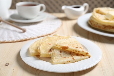 Photo of Tasty crepes served on wooden table, closeup