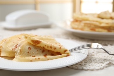 Photo of Tasty crepes on white wooden table, closeup