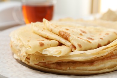 Photo of Tasty thin crepes on plate, closeup view