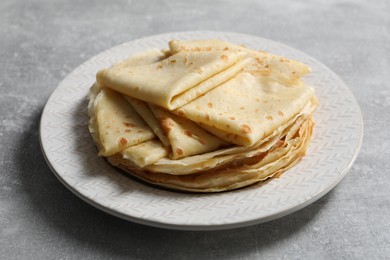 Photo of Tasty crepes on grey textured table, closeup