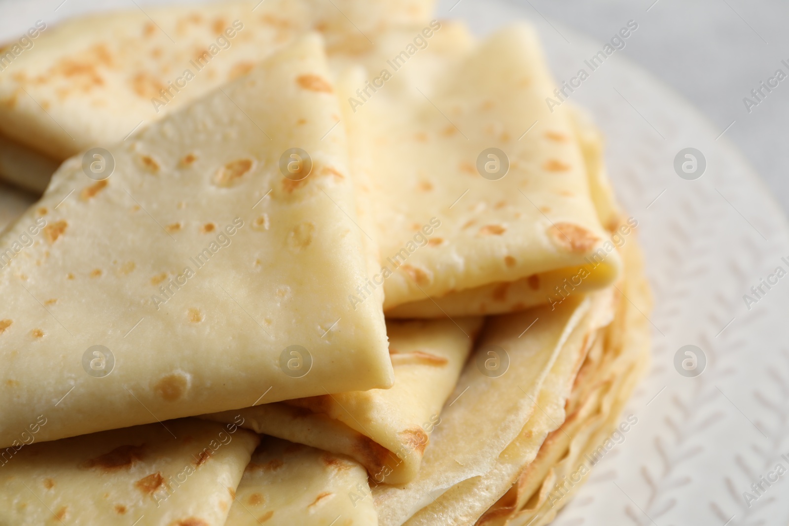 Photo of Tasty thin crepes on plate, closeup view