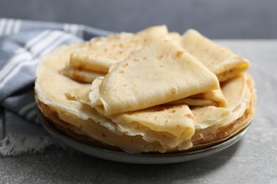 Photo of Tasty crepes on grey textured table, closeup