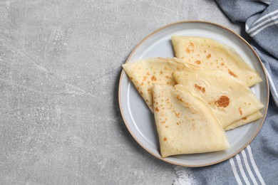 Tasty crepes on grey textured table, top view. Space for text