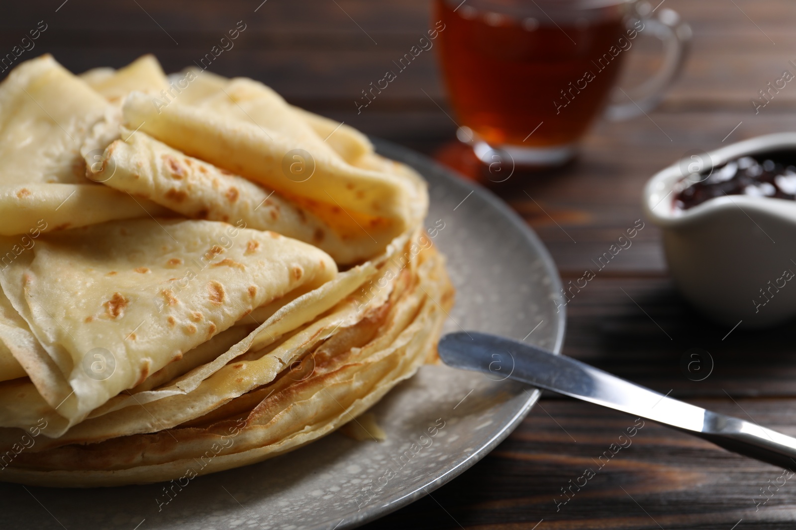 Photo of Tasty crepes on wooden table, closeup view