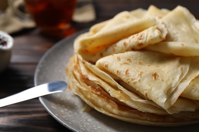 Photo of Tasty crepes on wooden table, closeup view