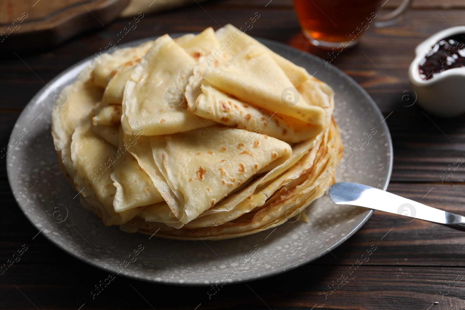 Photo of Tasty crepes on wooden table, closeup view