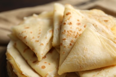 Photo of Tasty thin crepes on blurred background, closeup