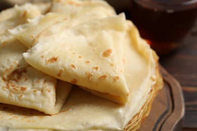 Photo of Tasty thin crepes on wooden table, closeup