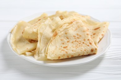 Tasty crepes on white wooden table, closeup