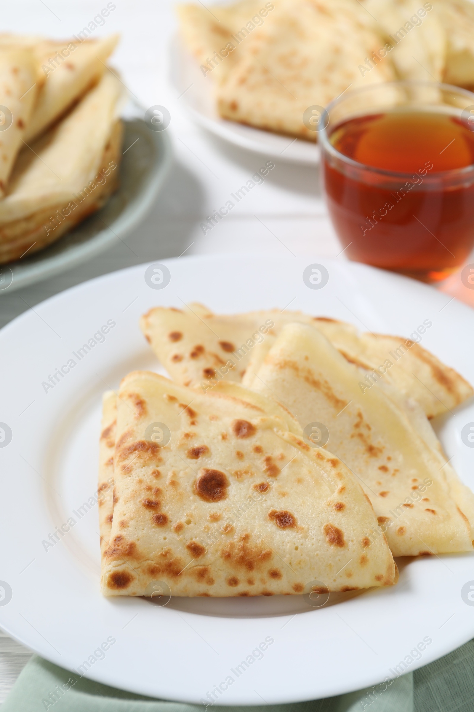 Photo of Tasty crepes served on white table, closeup