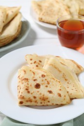 Photo of Tasty crepes served on white table, closeup