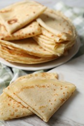 Photo of Many tasty thin crepes on table, closeup