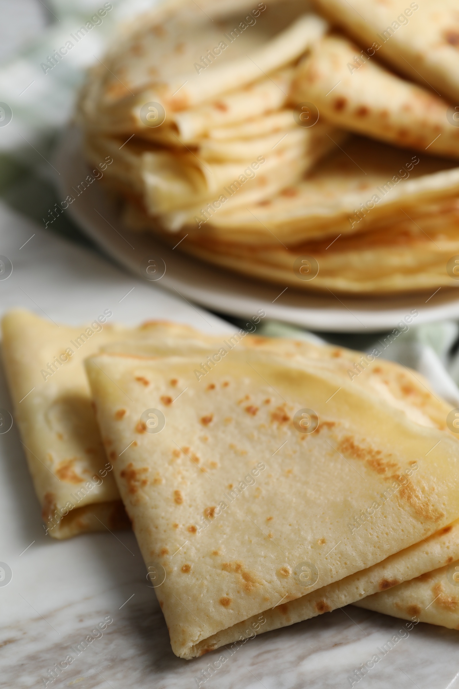 Photo of Many tasty thin crepes on table, closeup