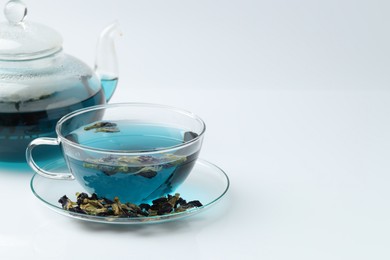 Photo of Fresh butterfly pea flower tea and dry petals on white table, closeup. Space for text