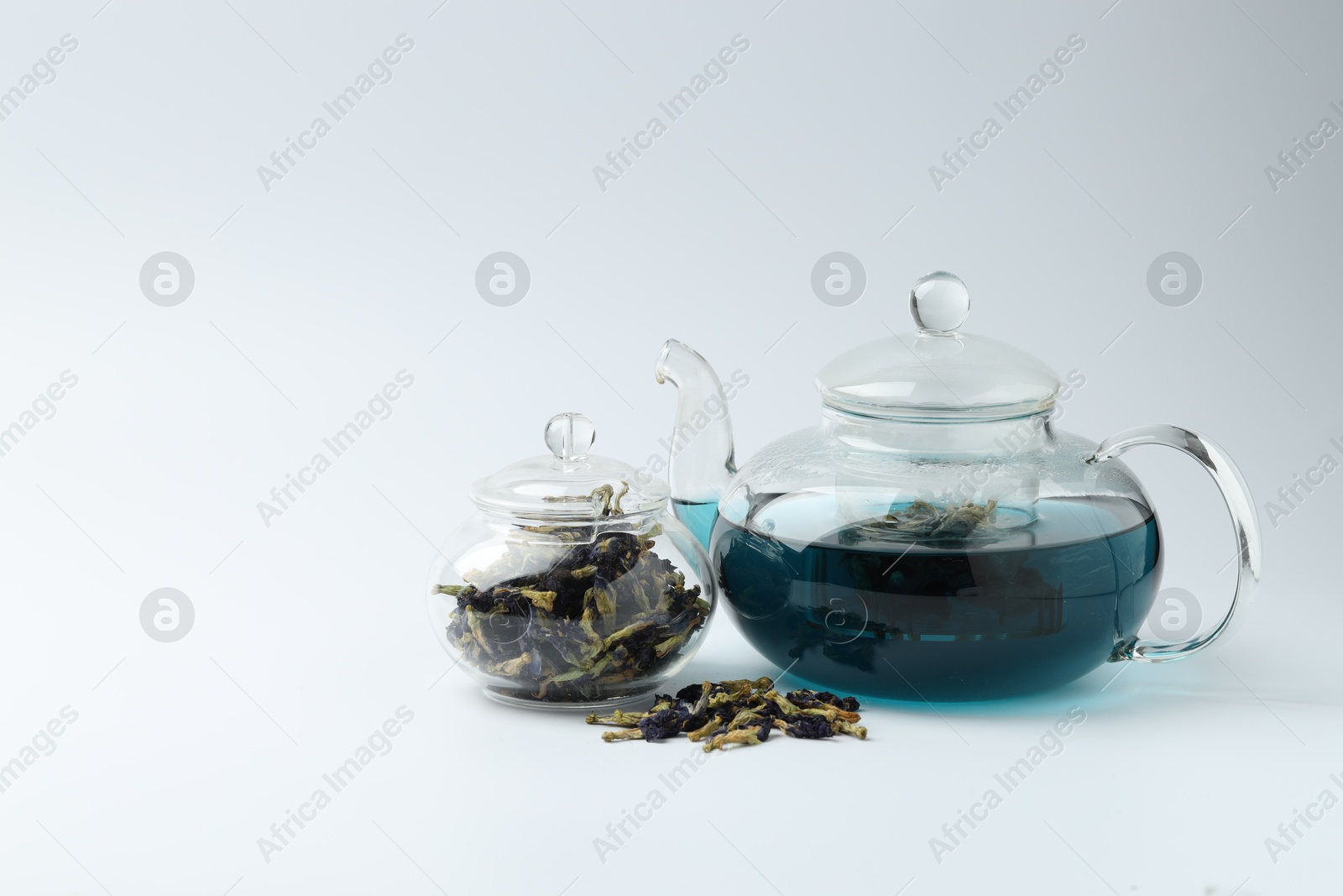 Photo of Fresh butterfly pea flower tea and dry petals on white table. Space for text