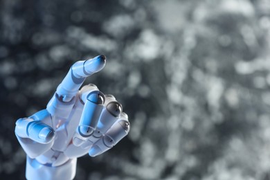 Photo of Artificial intelligence. Robot hand pointing at something on grey blurred background, space for text