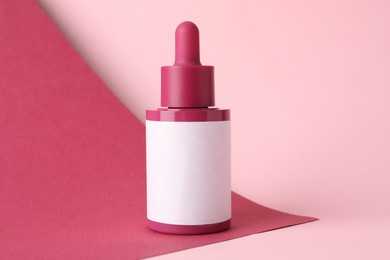 Photo of Bottle of skin care product on pink background