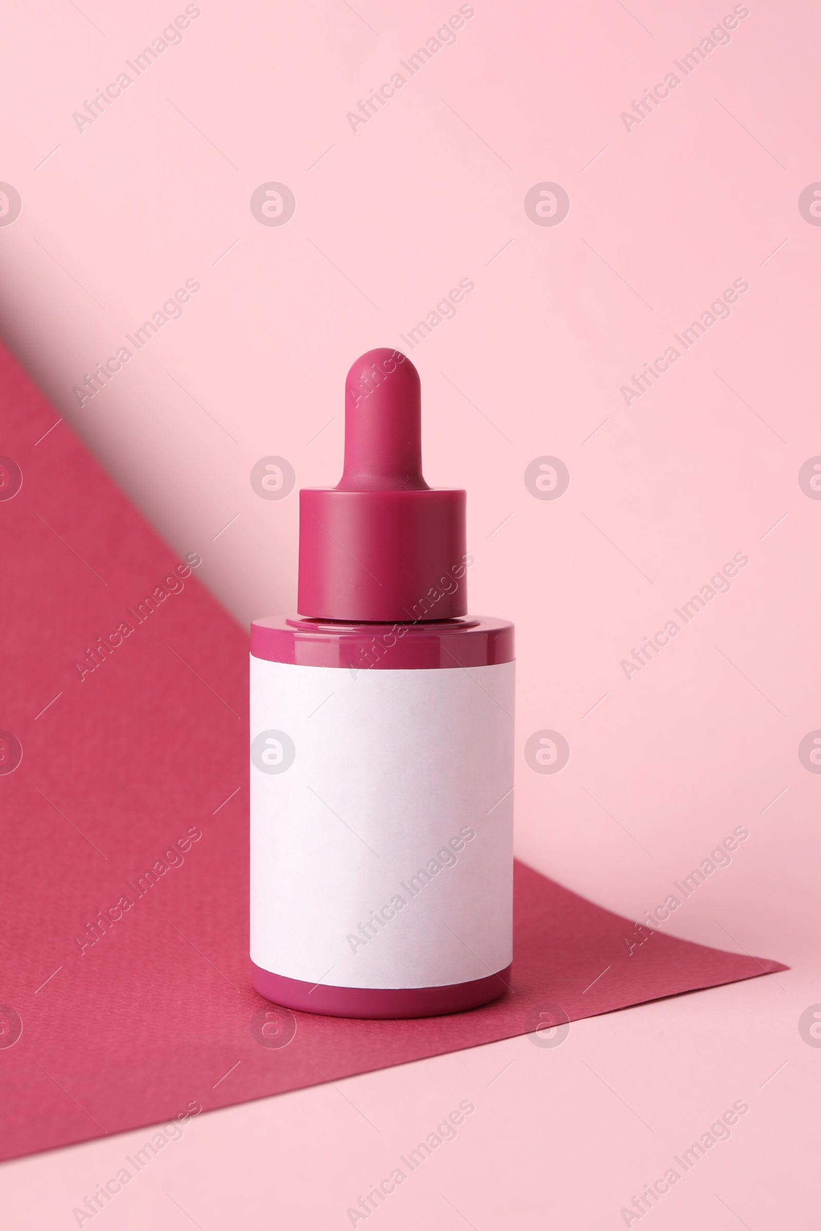 Photo of Bottle of skin care product on pink background