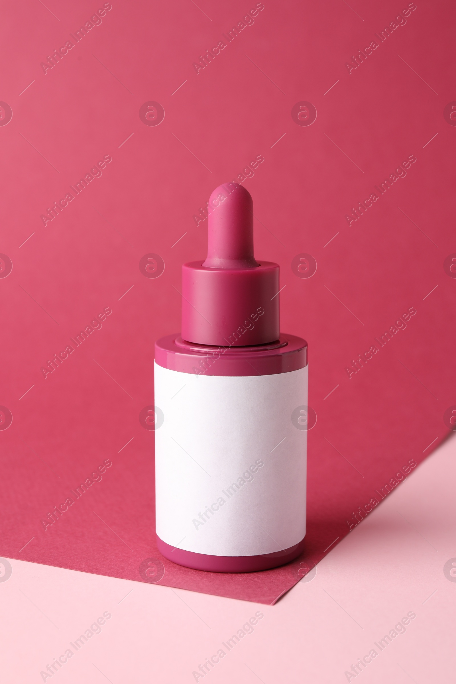 Photo of Bottle of skin care product on pink background