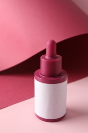 Bottle of skin care product on pink background