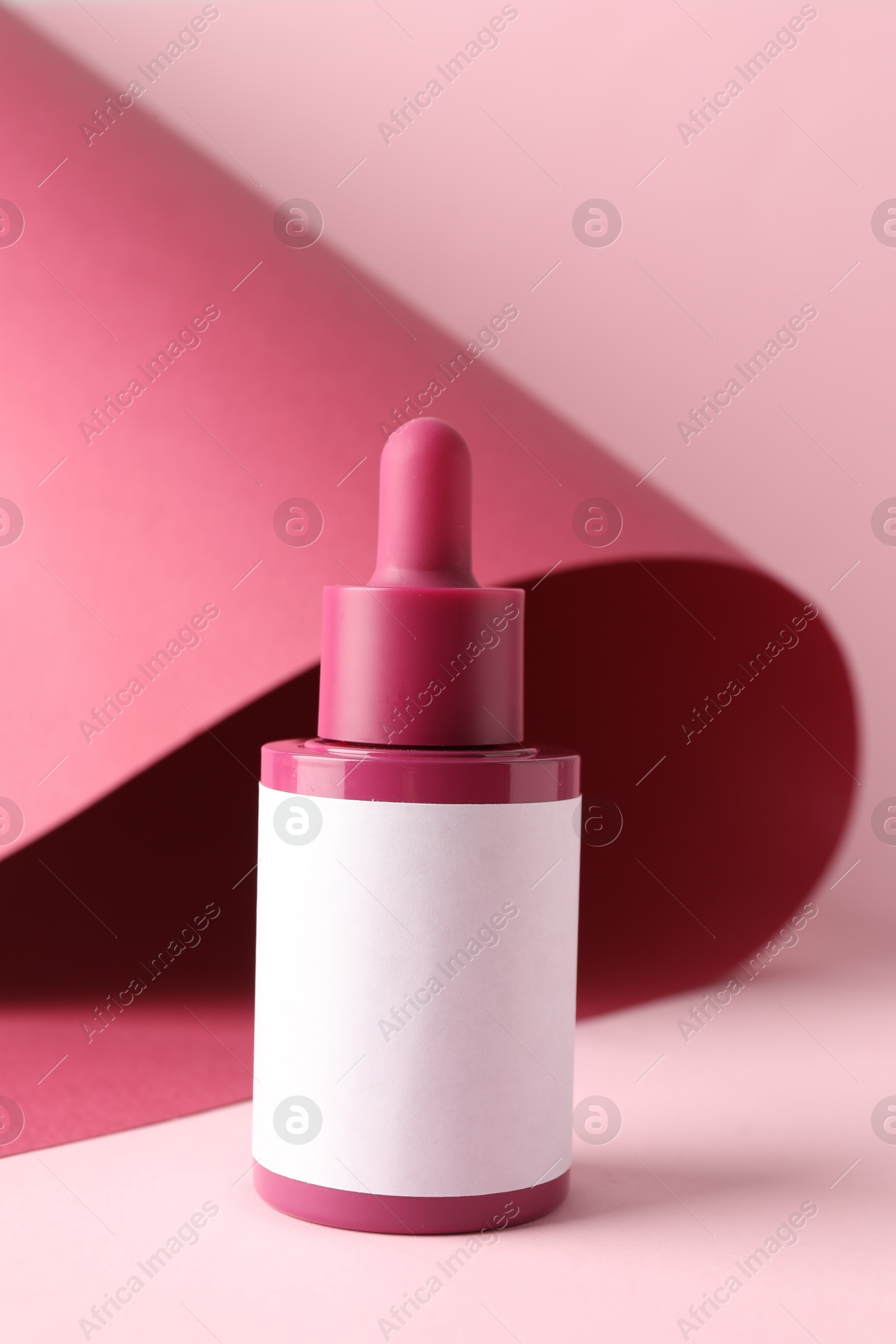 Photo of Bottle of skin care product on pink background