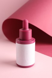 Bottle of skin care product on pink background